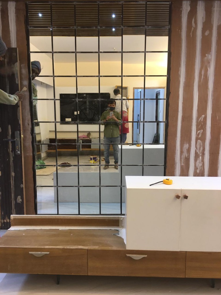 Steel grid glass partition with TV unit under construction